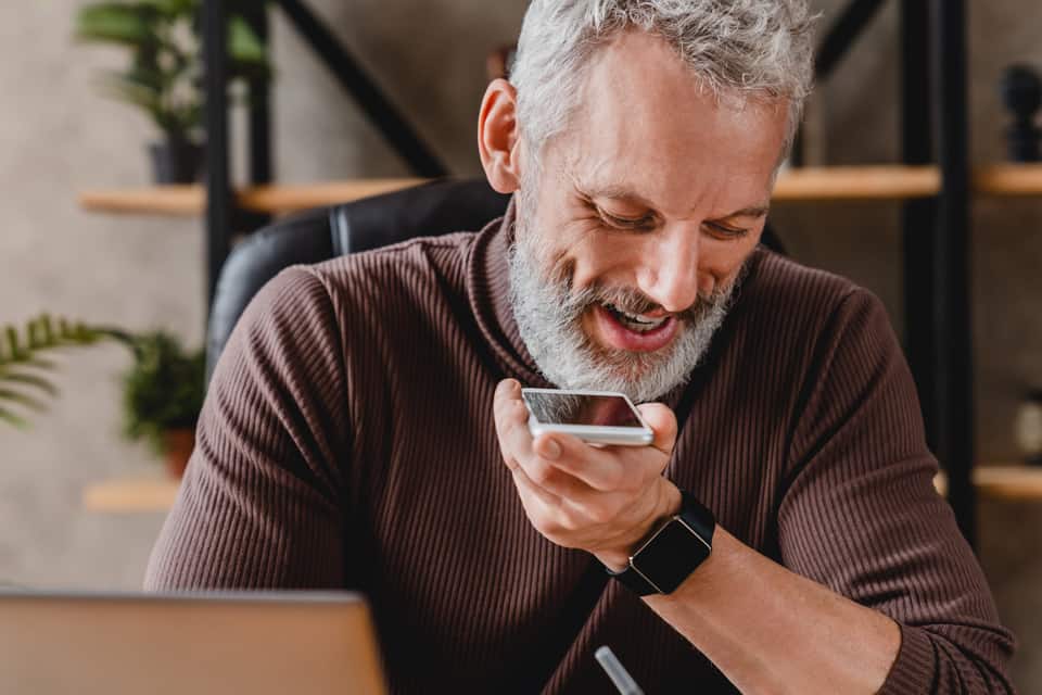 Man holds his phone up to use an automated voice service