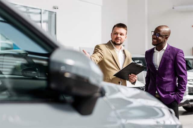 Two professionals discussing the auto history of a vehicle.
