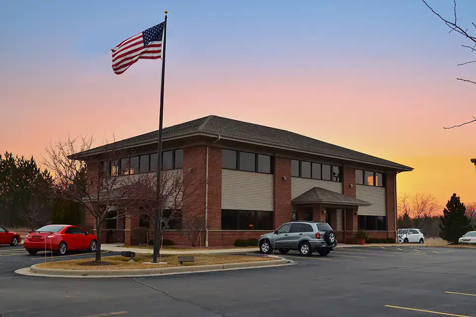Exterior view of the Burlington branch with American flag at sunset.