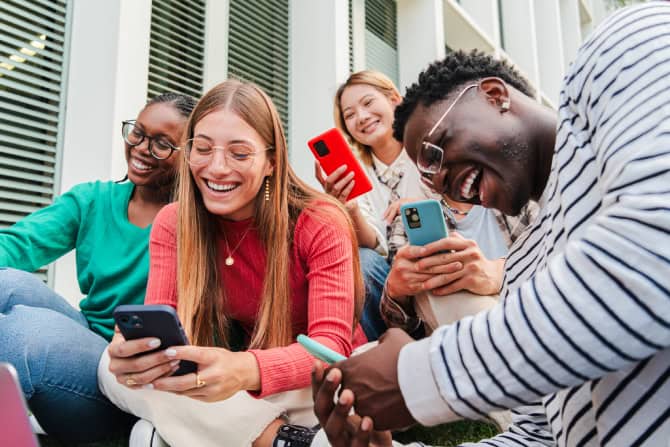 young adults using smartphones outdoors