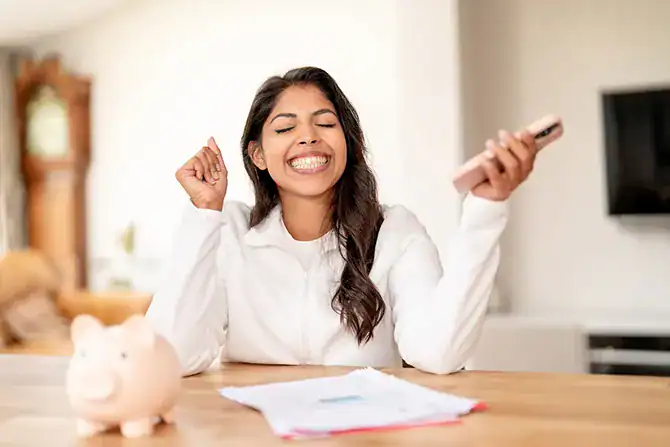 Happy woman celebrating savings with her checking account and change up savings.