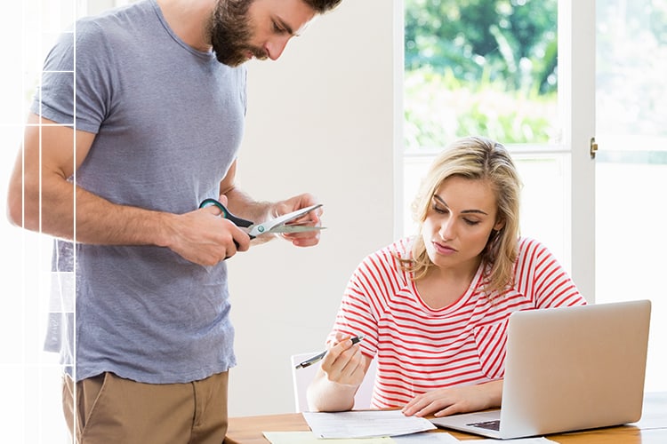 couple working on finances cutting up a credit card