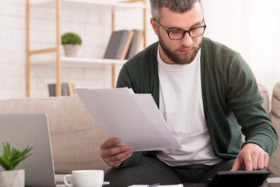 man sorting through paper at home