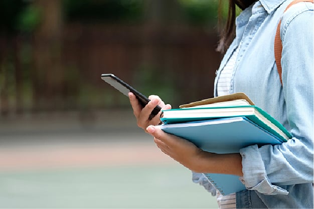 Estudiante con libros y teléfono