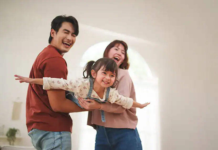 Happy family playing and laughing indoors, celebrating the completion of estate planning.