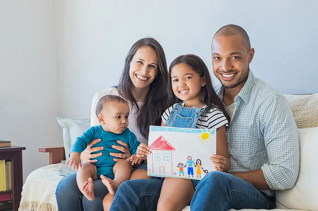 Family with children holding a drawing of a house, promoting planning for the future.