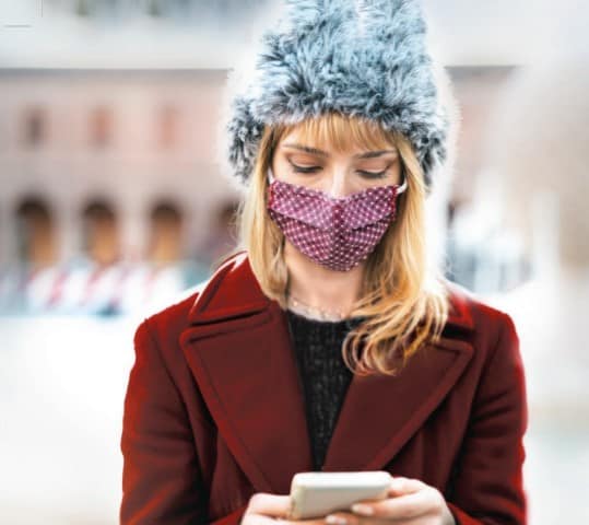 Woman with mask checking phone