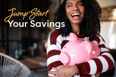 woman smiling and holding a piggy bank