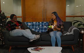 Two people enjoying a holiday celebration at Educators CU office lounge.