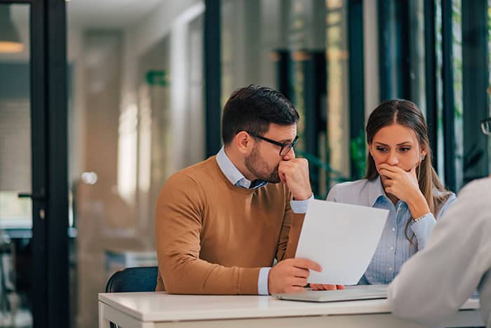 A couple sitting in an office going over loan scam information.