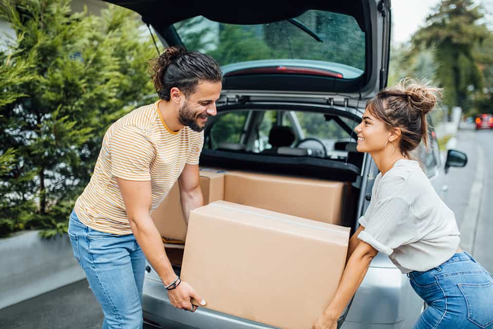couple moving boxes from car