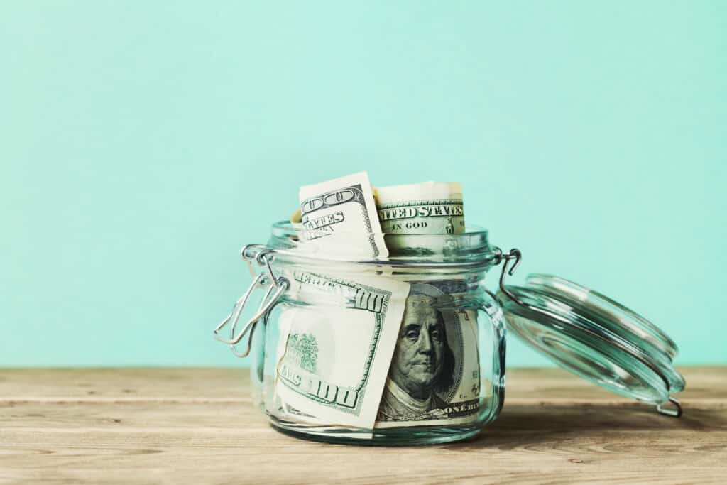 Dollar bills in glass jar. Saving money, economy, finance