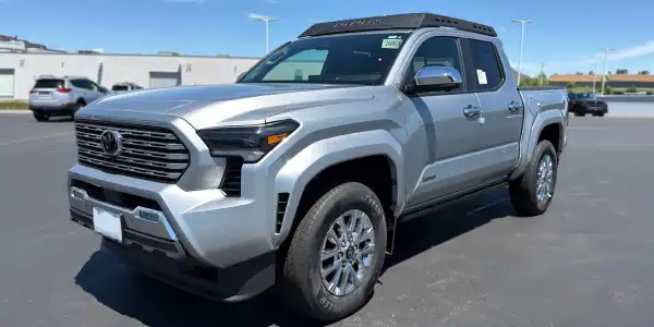 Silver Toyota Tundra pickup truck parked in dealership lot on sunny day.