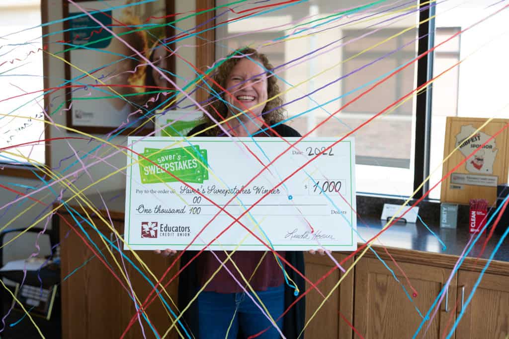 Mujer sonriendo y sosteniendo un gran cheque