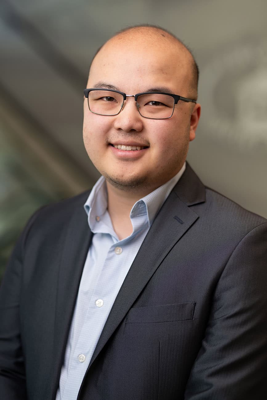 Professional portrait of a smiling man in business attire for Investment Services.