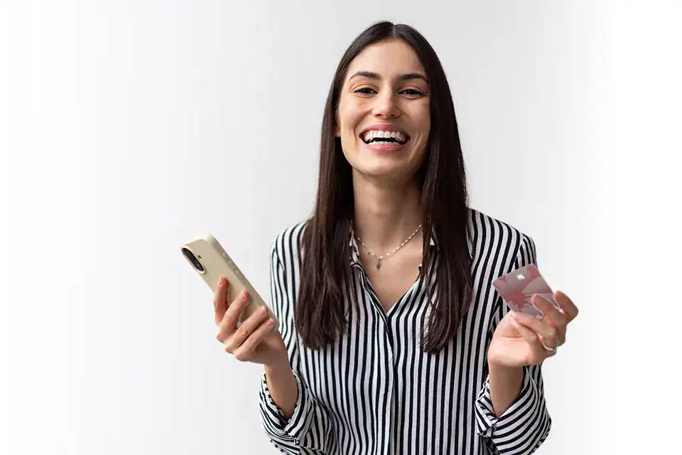 Happy young woman using smartphone and debit card after opening a personal checking account.