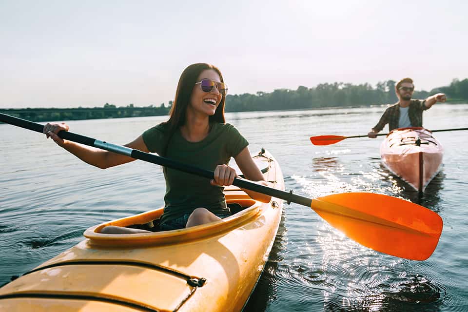 A young couple kayaks and smiles