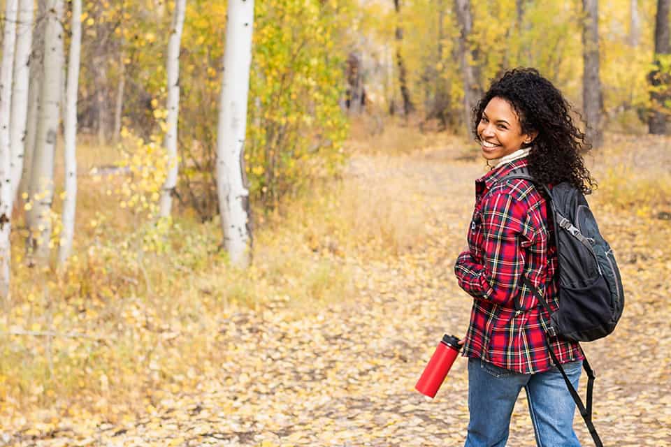 Woman enjoys a hike through an autumn forest