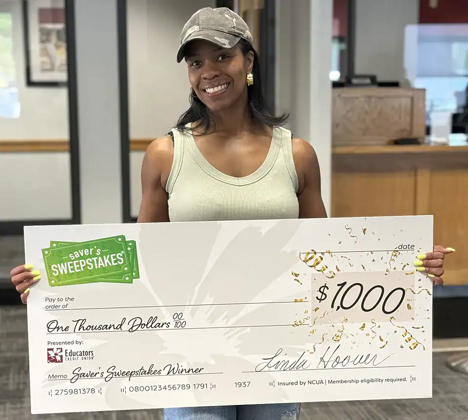 Woman holding a $1,000 savers sweepstakes check.