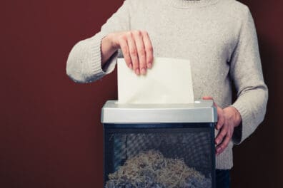 person shredding a piece of paper