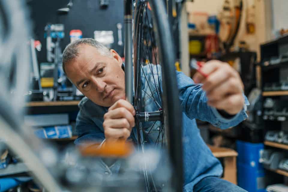 Un hombre trabaja en una bicicleta en un taller.