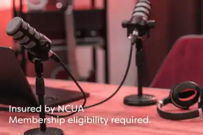 Microphones sitting on table in podcast for Talking Dollars & Sense