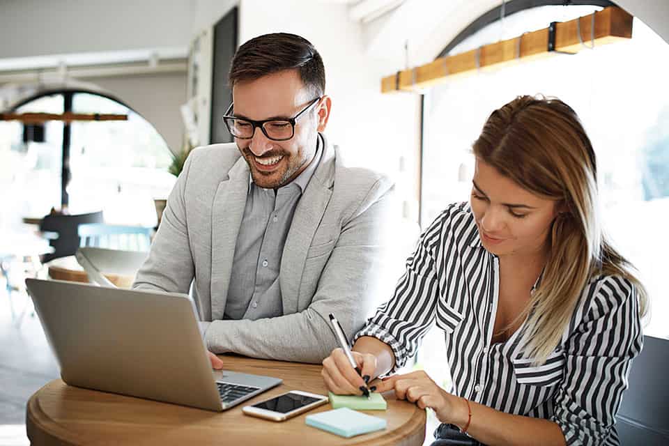 compañeros de trabajo en la computadora portátil en el escritorio trabajando