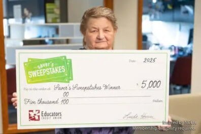 Woman holding Saver's Sweepstakes check