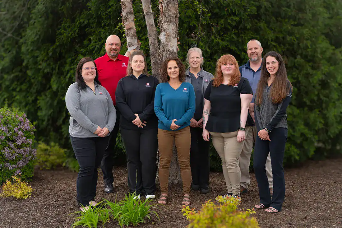 Staff from the Vehicle Solutions team standing outdoors in front of trees.