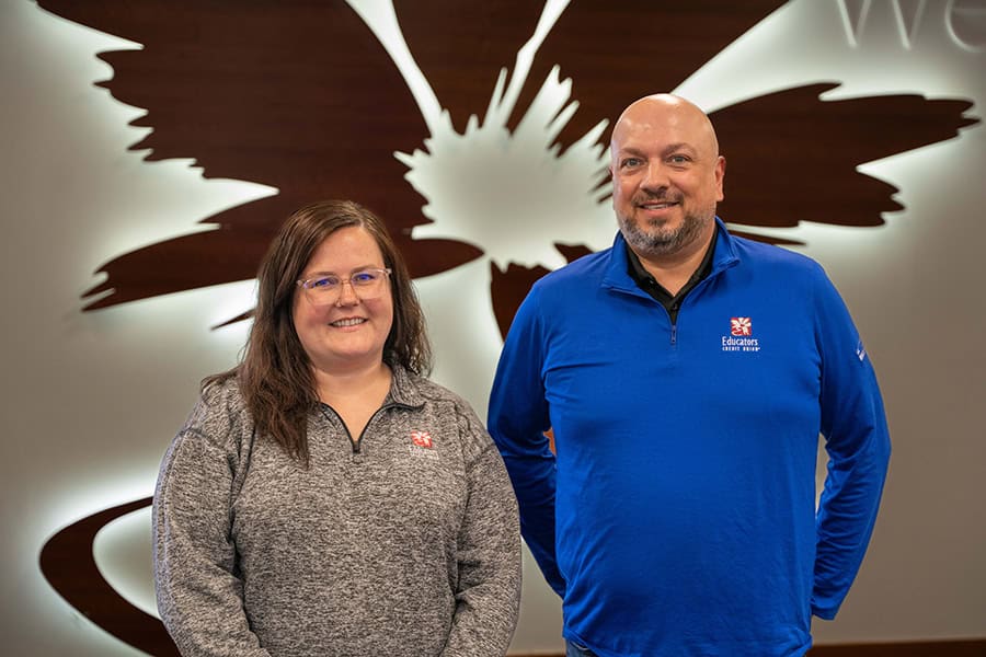 Vehicle Solutions staff members smiling in front of the credit union logo.