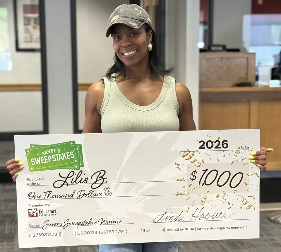 Woman holding a $1,000 savers sweepstakes check.