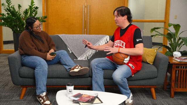 Two people on a couch talking to one another