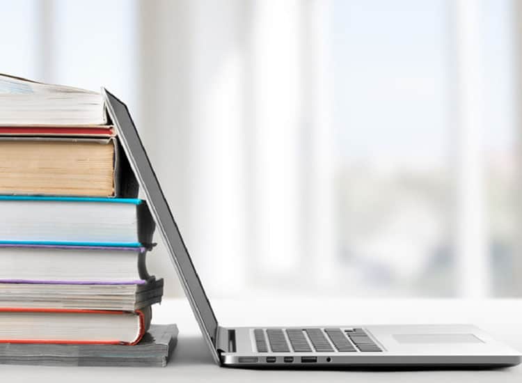 Stack of books with a computer