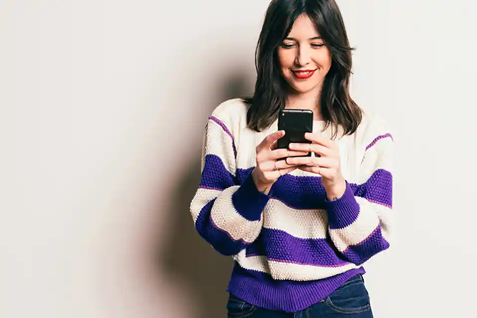 Young woman using Zelle on her phone.